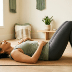 Woman practicing somatic yoga nervous system reset lying on mat with hands on chest and belly